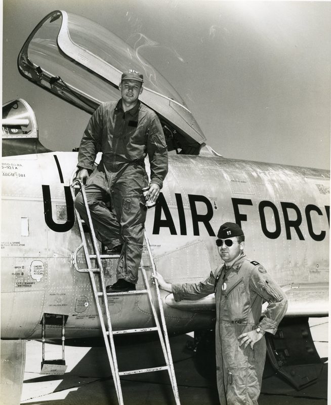 Colonel Bob Burns in the cockpit of an F-86D Sabre interceptor wearing a flight helmet, McChord Air Force Base, 1955